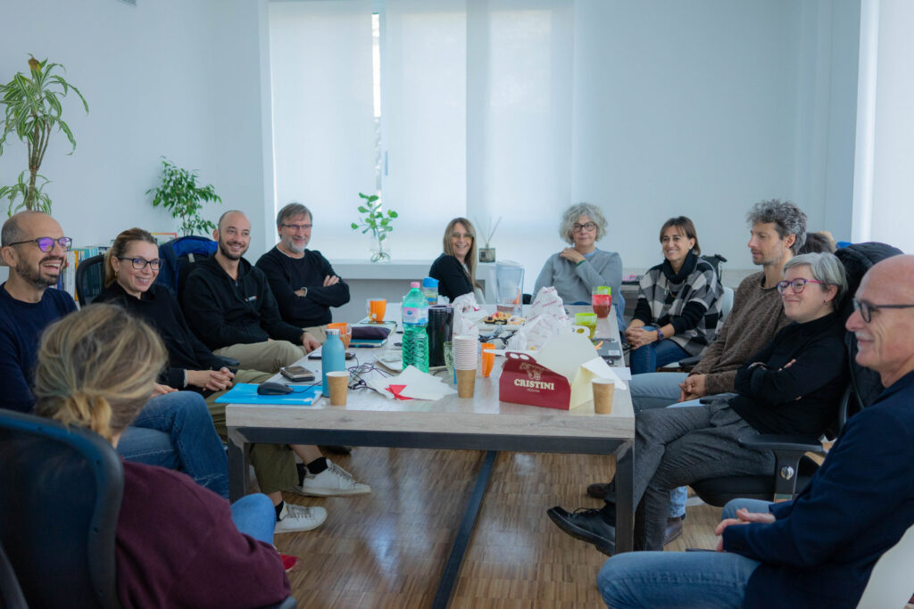 Gruppo di persone sorridenti durante una formazione per team coopattiva