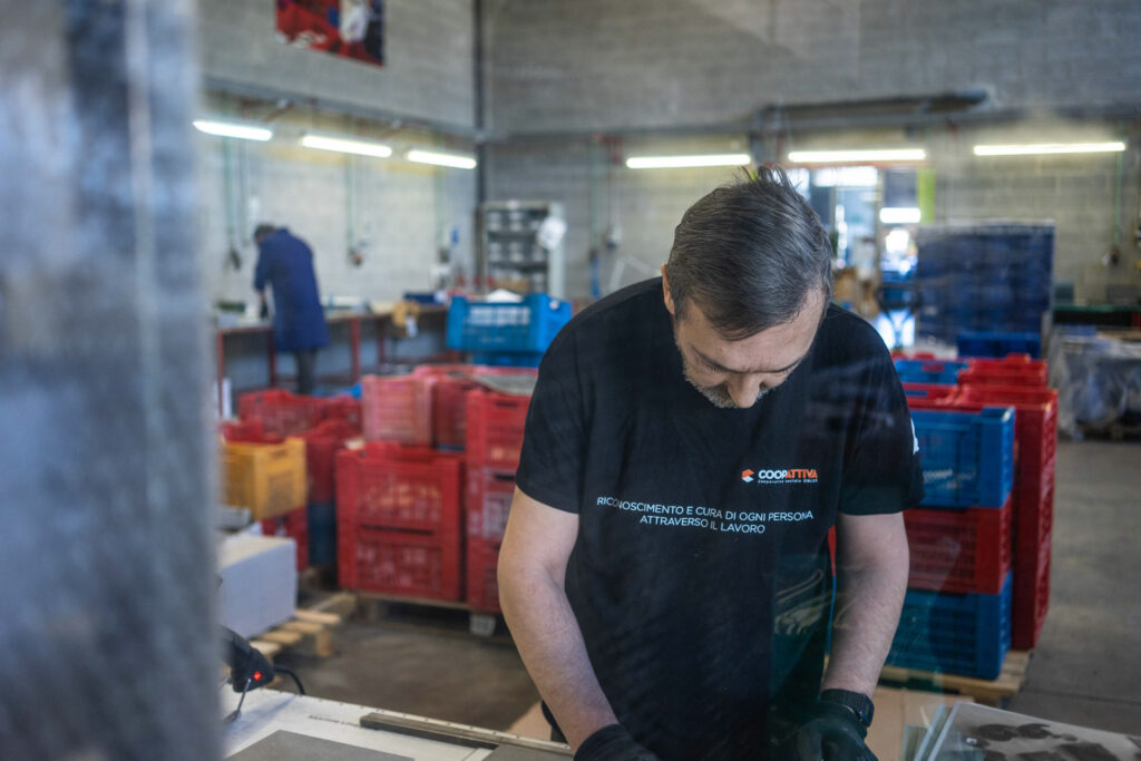 Ragazzo intento a lavorare a coopattiva. Ambiente di officina.