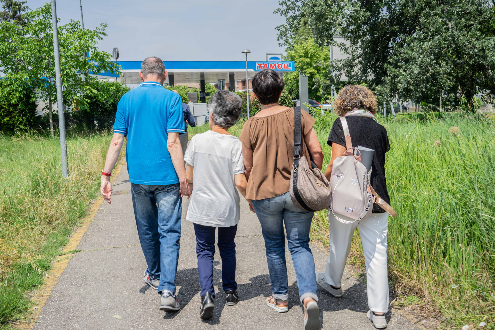 4 Persone che fanno una passeggiata all'aperto tenendosi per mano.