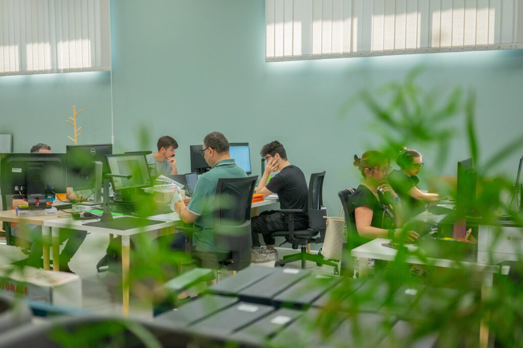 Vista Ufficio Puntilinea di coopattiva con diverse persone che stanno lavorando al computer.