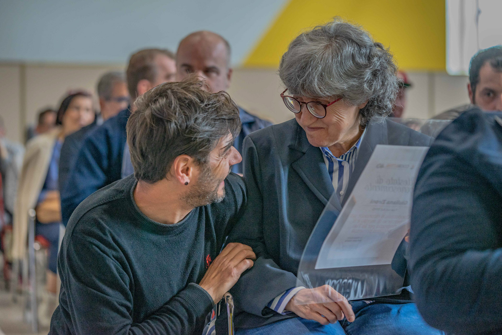 Uomo e donna durante una premiazione sorridenti.
