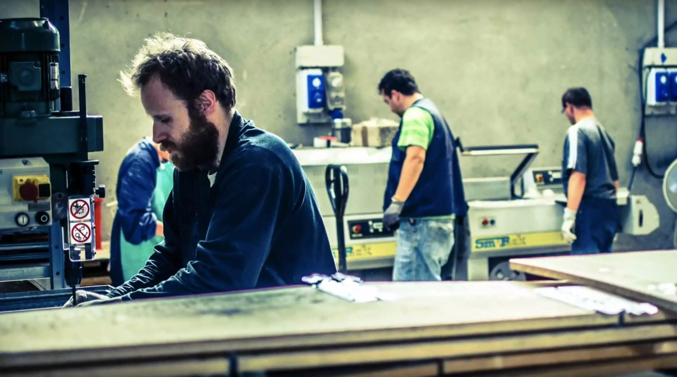 Uomo in azienda mentre sta lavorando ad un macchinario coopattiva