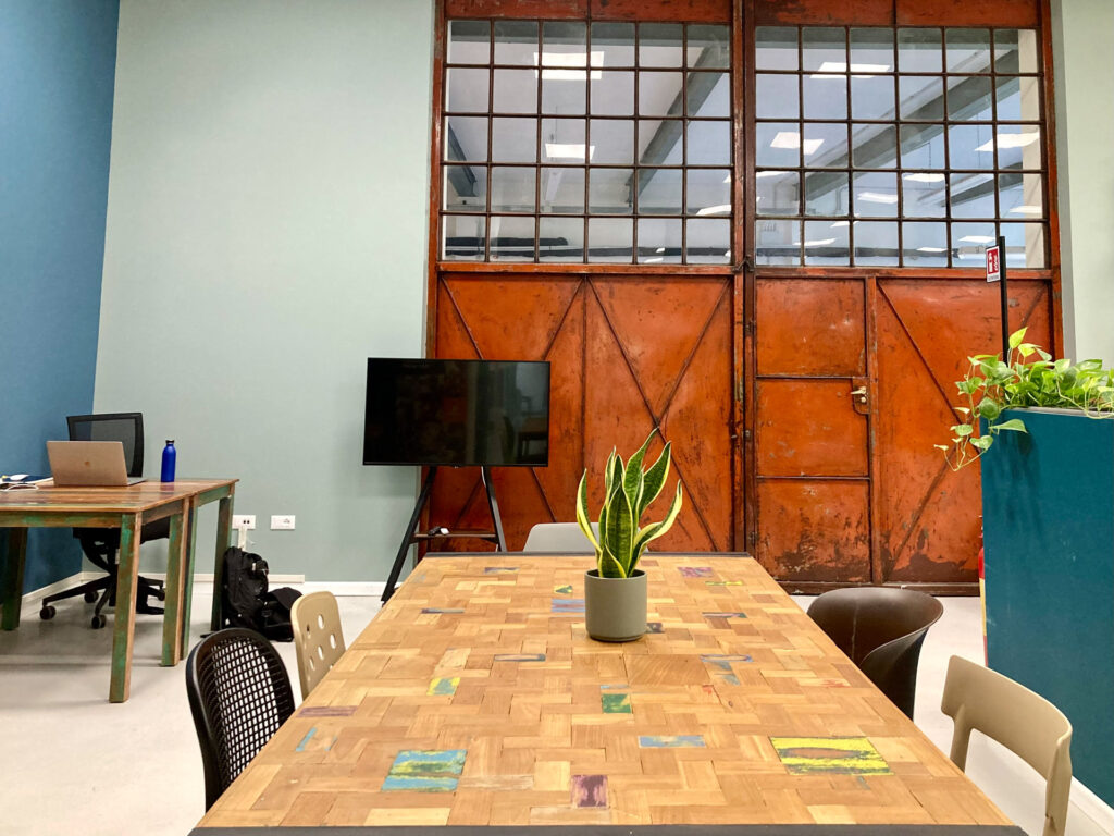 Veduta di una scrivania per postaione coworking coopattiva. Stile industrial.