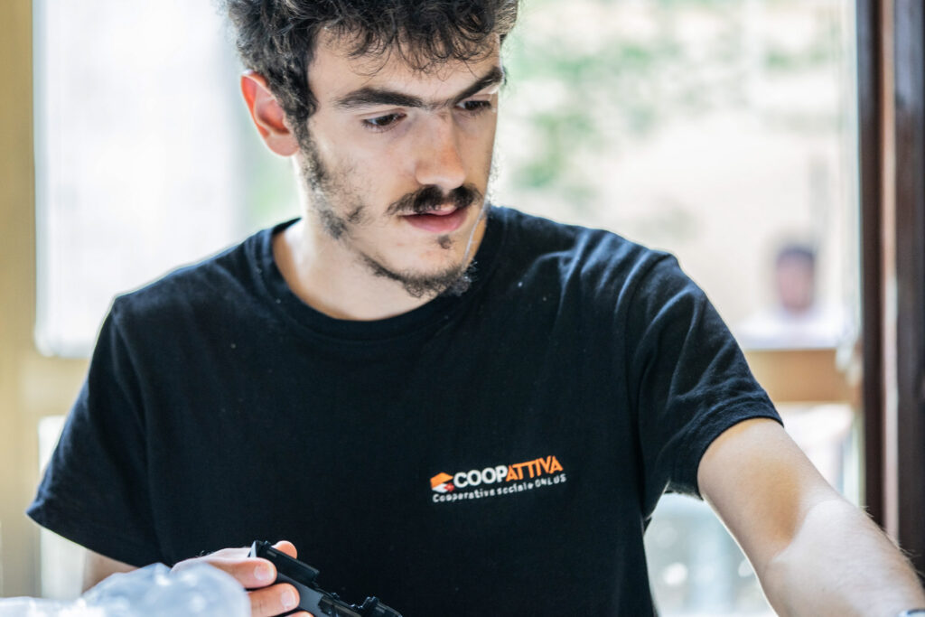 Uomo con maglia coopattiva mentre coordina lavorazioni.