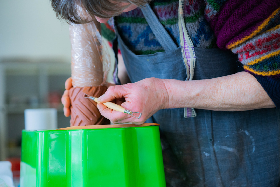 Donna mentre lavora argilla per laboratorio ceramico coopattiva